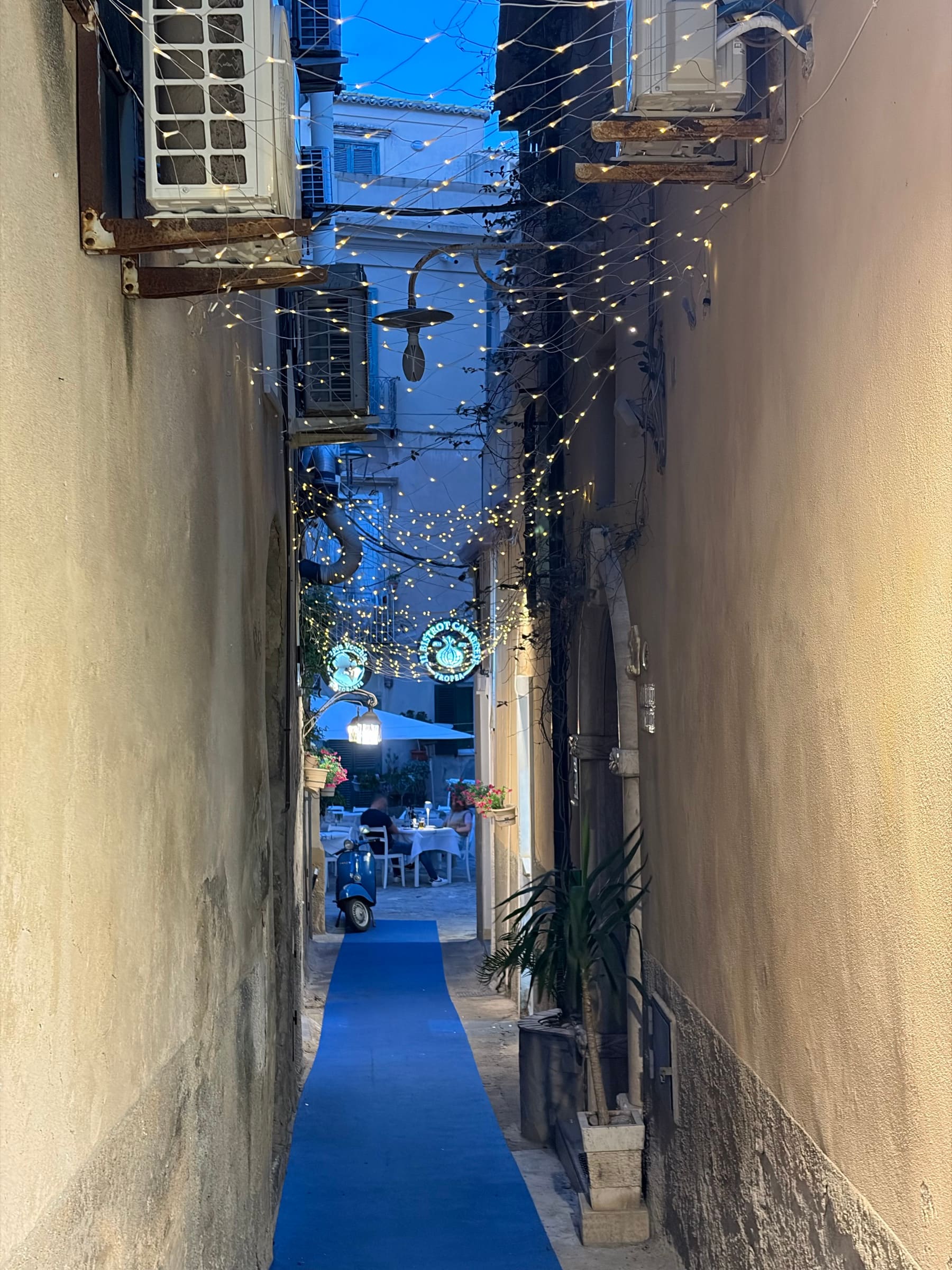 Schmale Gasse in Tropea bei Nacht mit Lichterketten